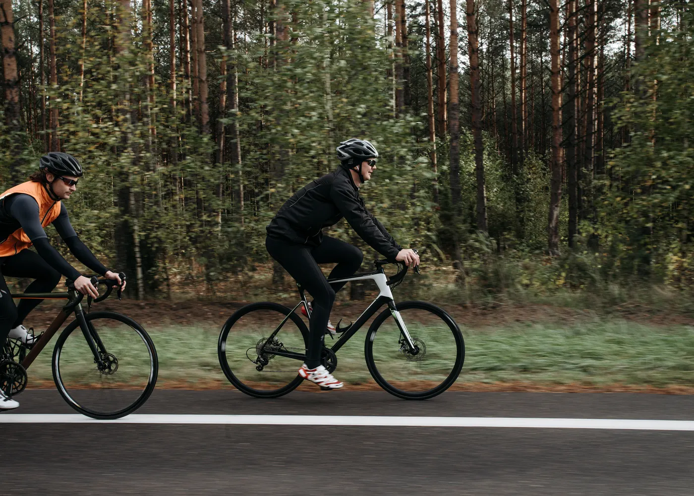 Dwóch rowerzystów jadących leśną drogą